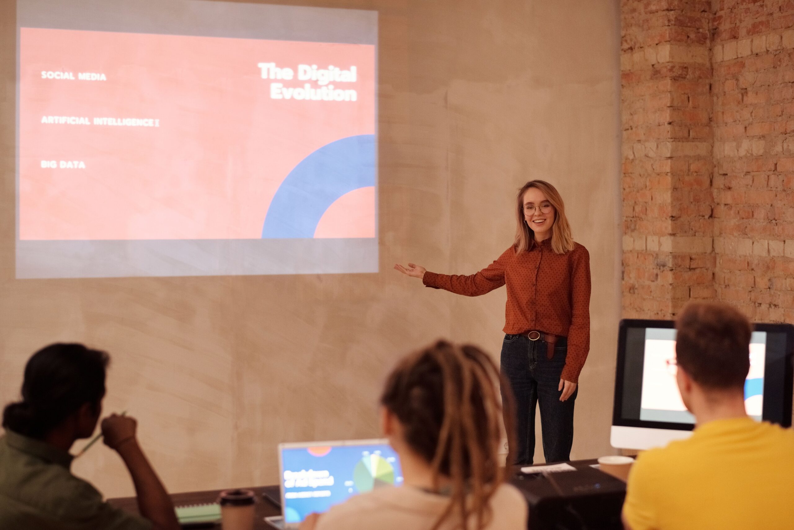 Spreker sluit een presentatie overtuigend af voor een betrokken publiek in een moderne ruimte