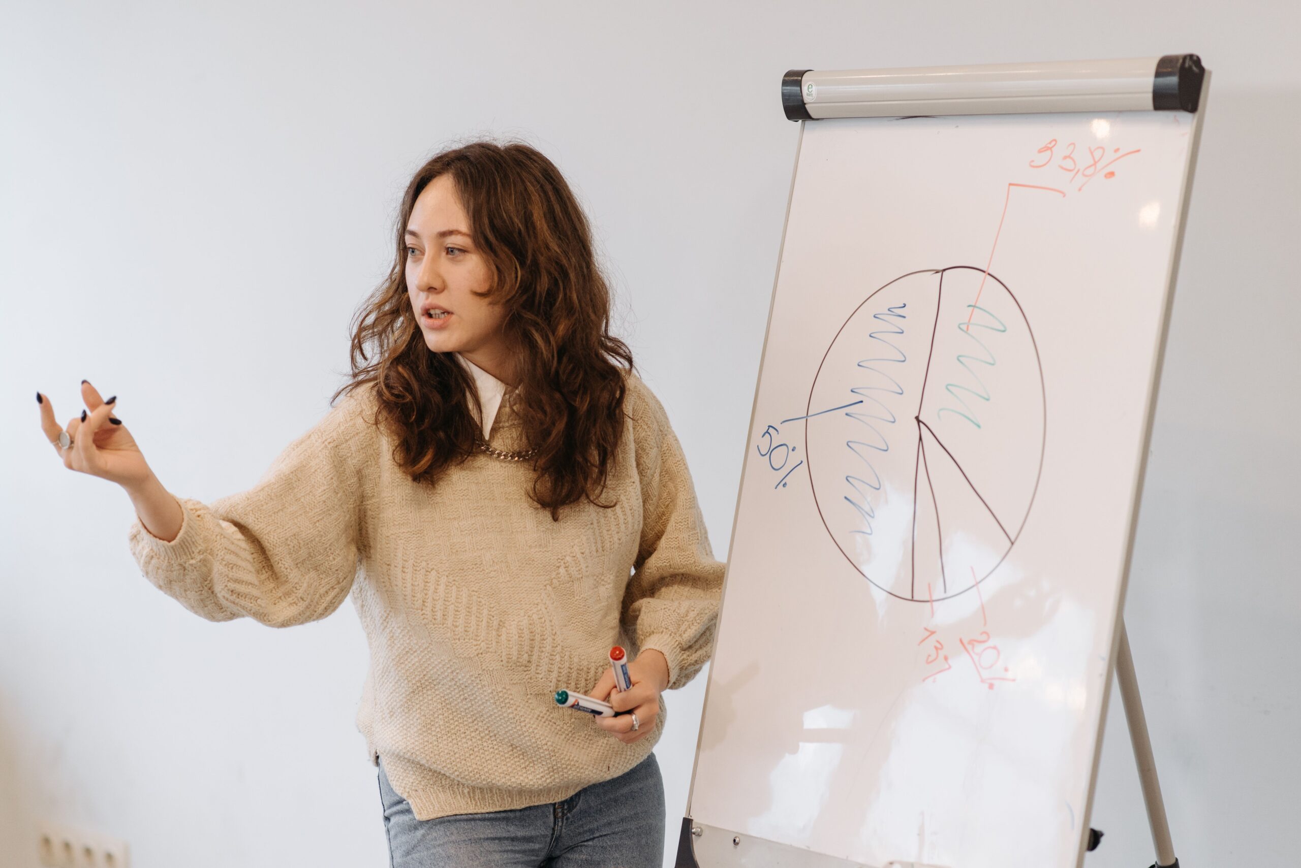 Vrouw die zelfverzekerd presenteert voor een kleine groep in een moderne vergaderruimte